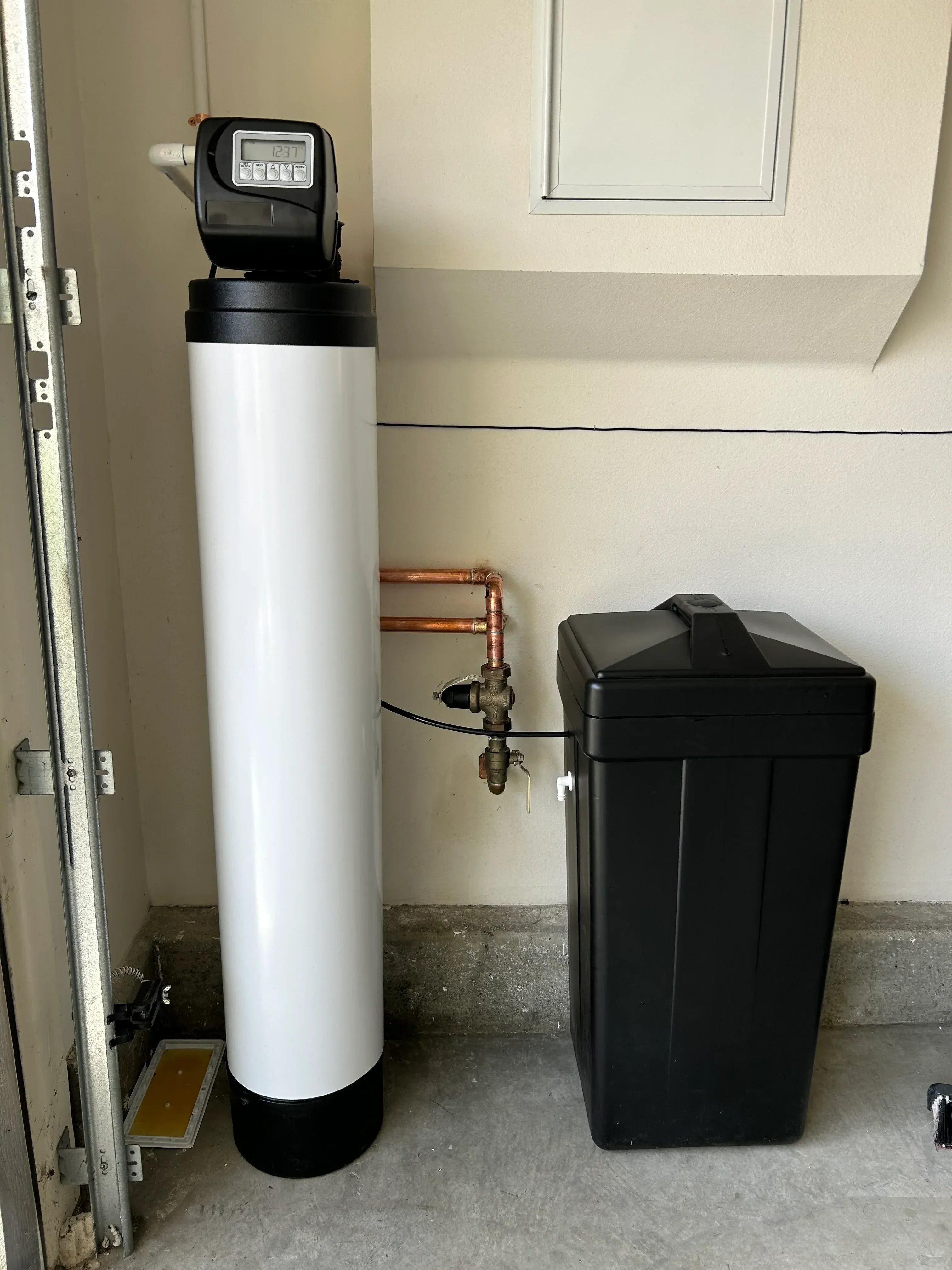 Water softener tank with digital control valve, brine tank, and copper supply line connections