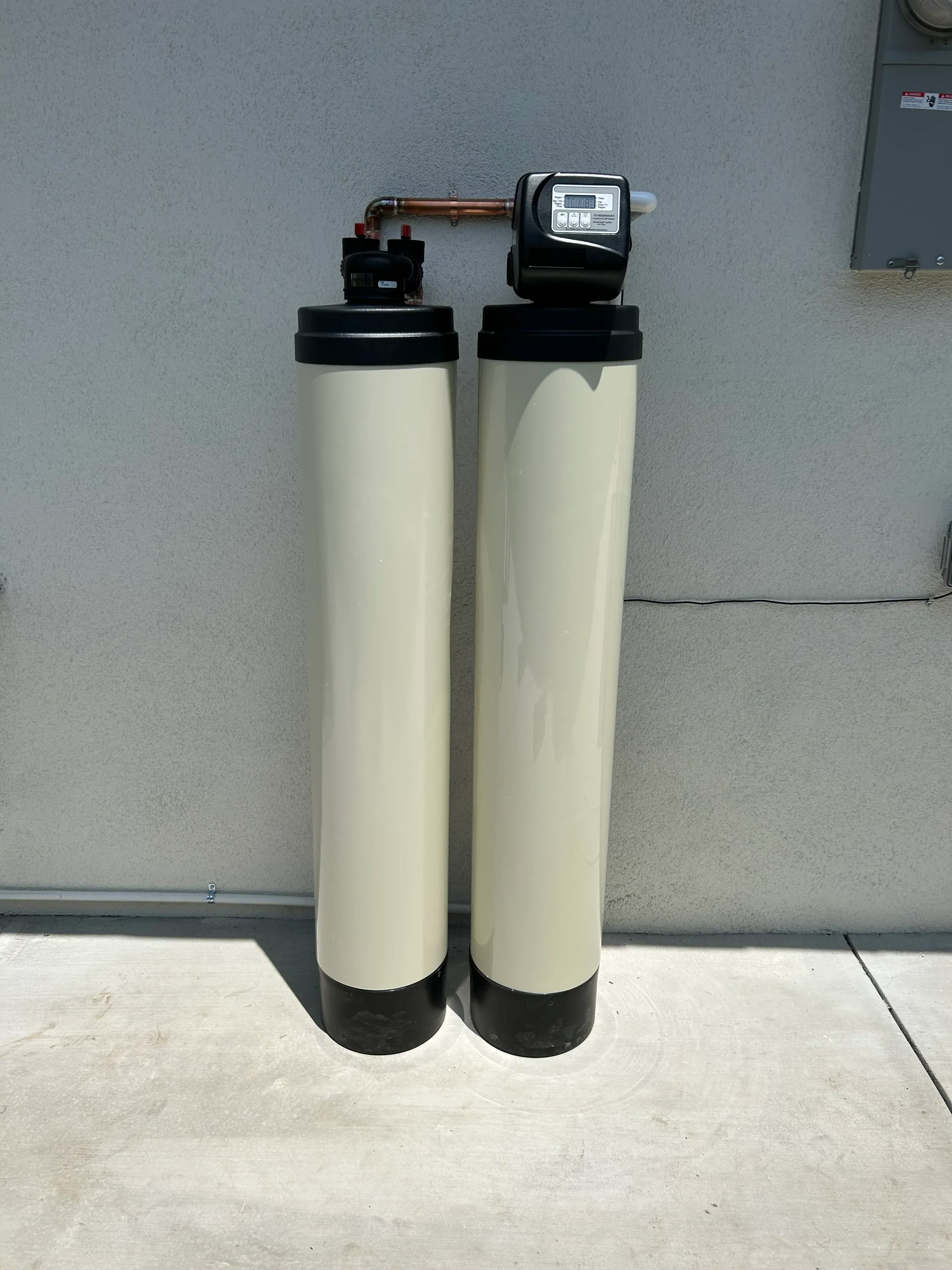 Dual tank water softener with cream resin vessels, digital control valve, and copper connections