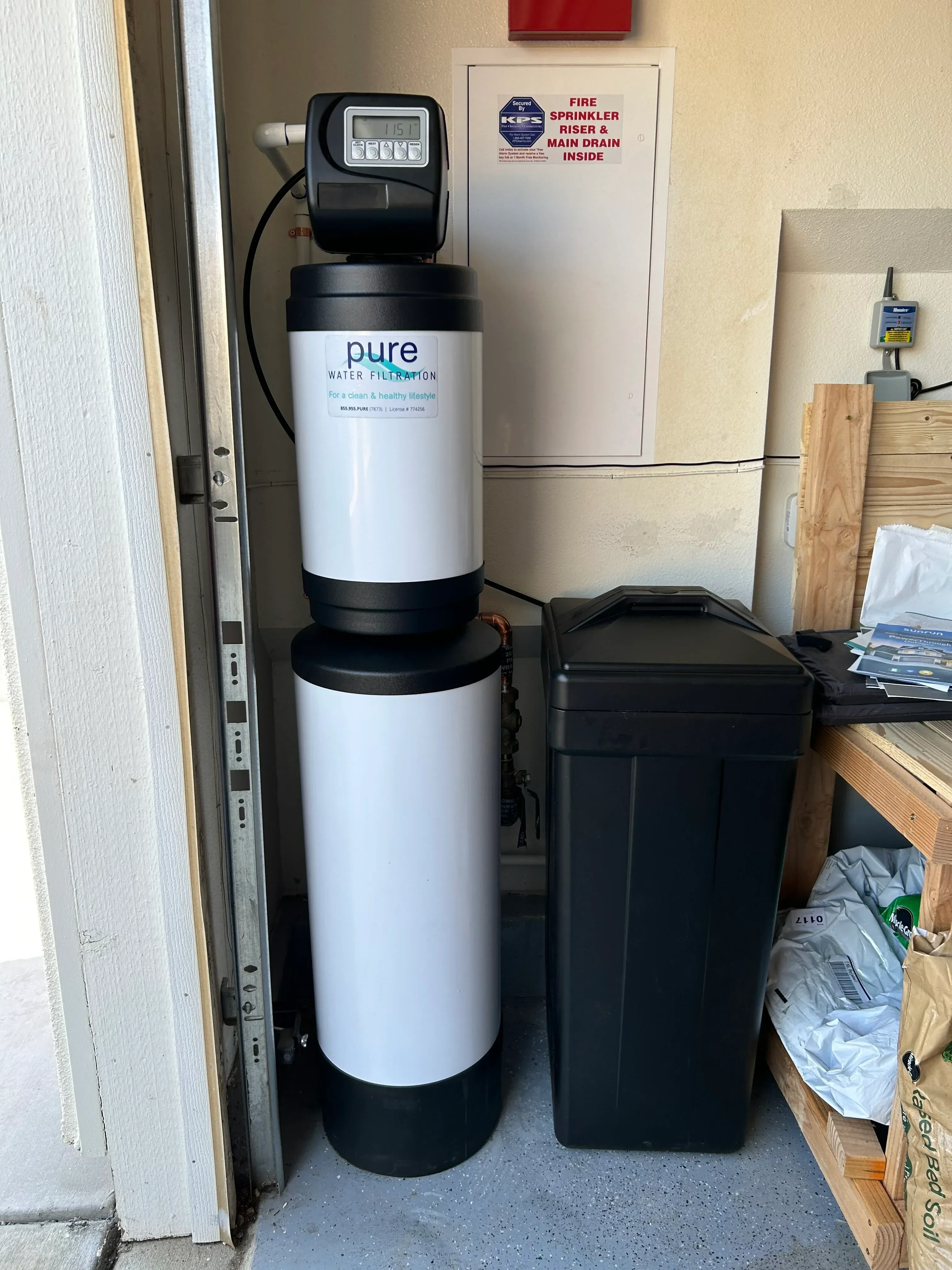 Pure water filter cartridge with black control valve and secondary tank mounted in utility cabinet